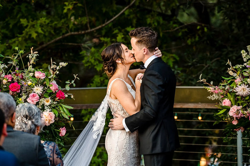 Bride and groom first kiss outdoors in serene wedding ceremony