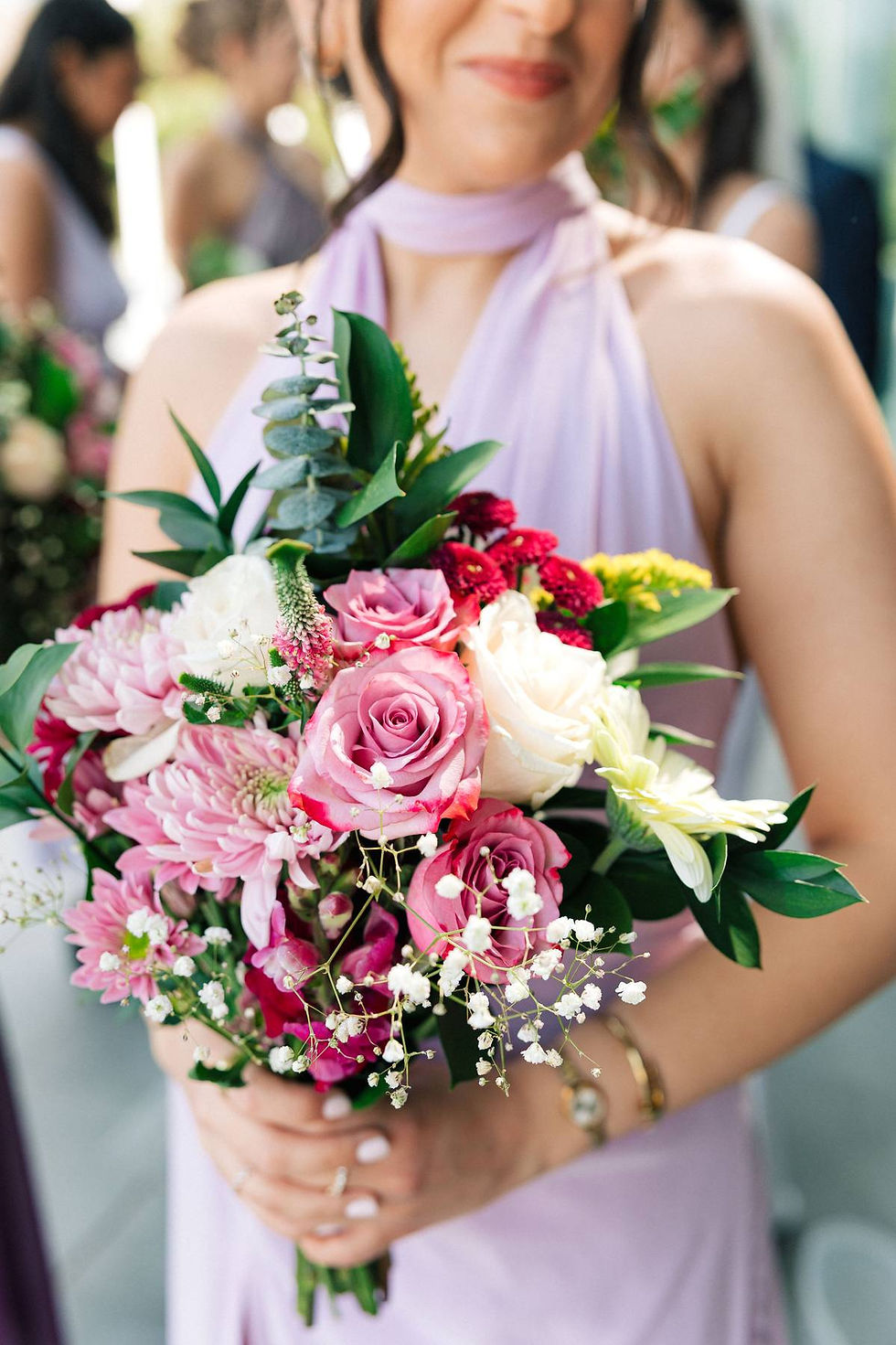 Colorful bridesmaid bouquet with pink, white, and burgundy wedding flowers.