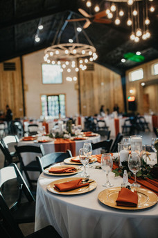 Reception setup with warm lighting and orange accents at Houston wedding.