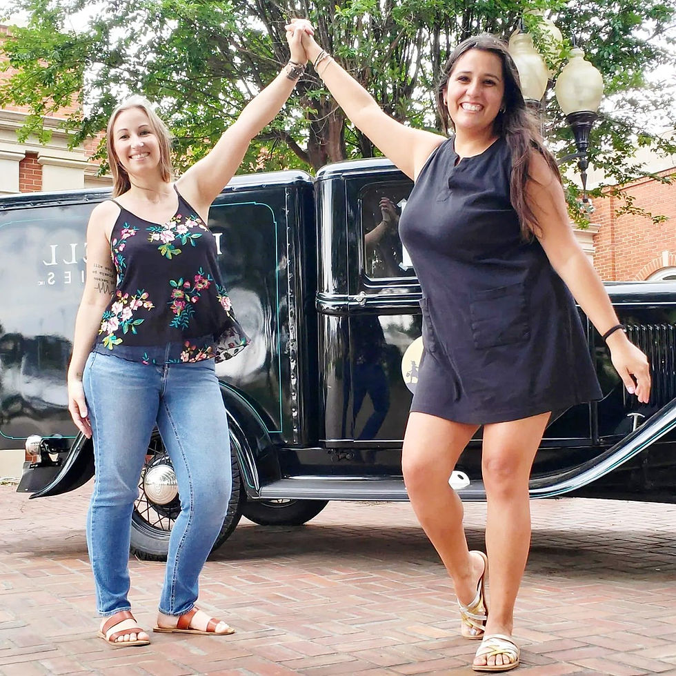 Texas wedding planners posing beside a vintage truck at Rockin’ Star Ranch.
