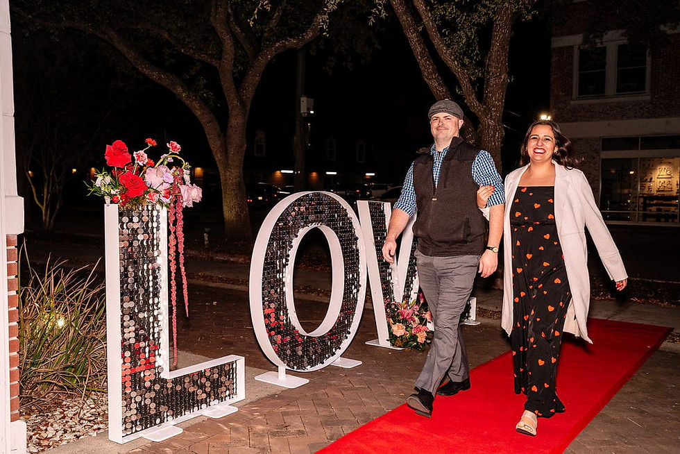 Brandi walking past large LOVE letters at night with husband.
