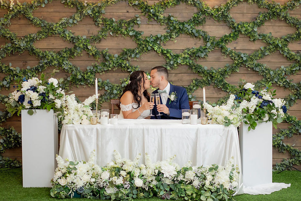 Bride and groom toasting at floral sweetheart table at the Reserve at Cypress Creek, Texas venue.