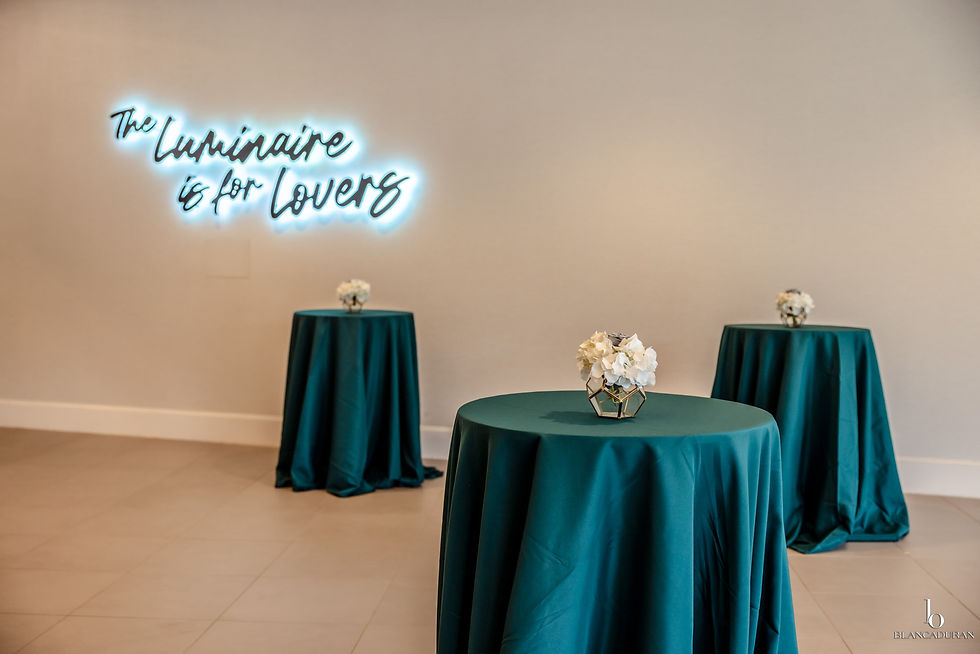 Cocktail tables with teal linens and white florals.