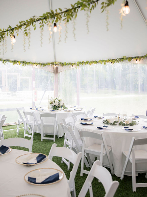 Tent wedding reception with white tables and greenery decor in Texas.
