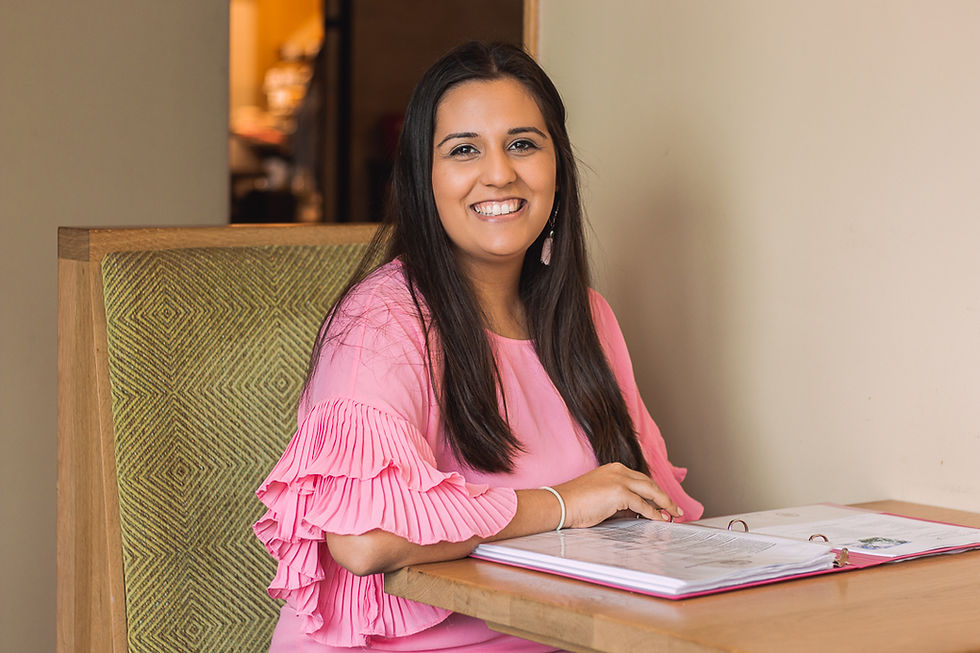 Brandi sits with a planning binder and smiles at the camera.