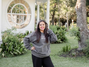 Brandi Swanson standing outside a white chapel at a Texas wedding venue.