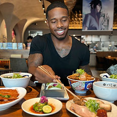 Patrick Blackwood using chopsticks to eat at a restaurant promotion.