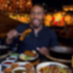 Surprised Patrick Blackwood holding grilled food at a restaurant