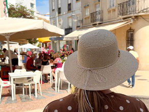 Tara walking around the streets of Portugal with a straw hat on.