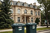 big mansion with two trash bins neatly against the street to the side.jpg