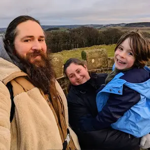 Family selfie with Nathan, Whit, and Theo, smiling happily outdoors