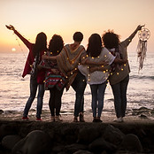 Dreaming image with group of females friends hug each other all together looking the sunse