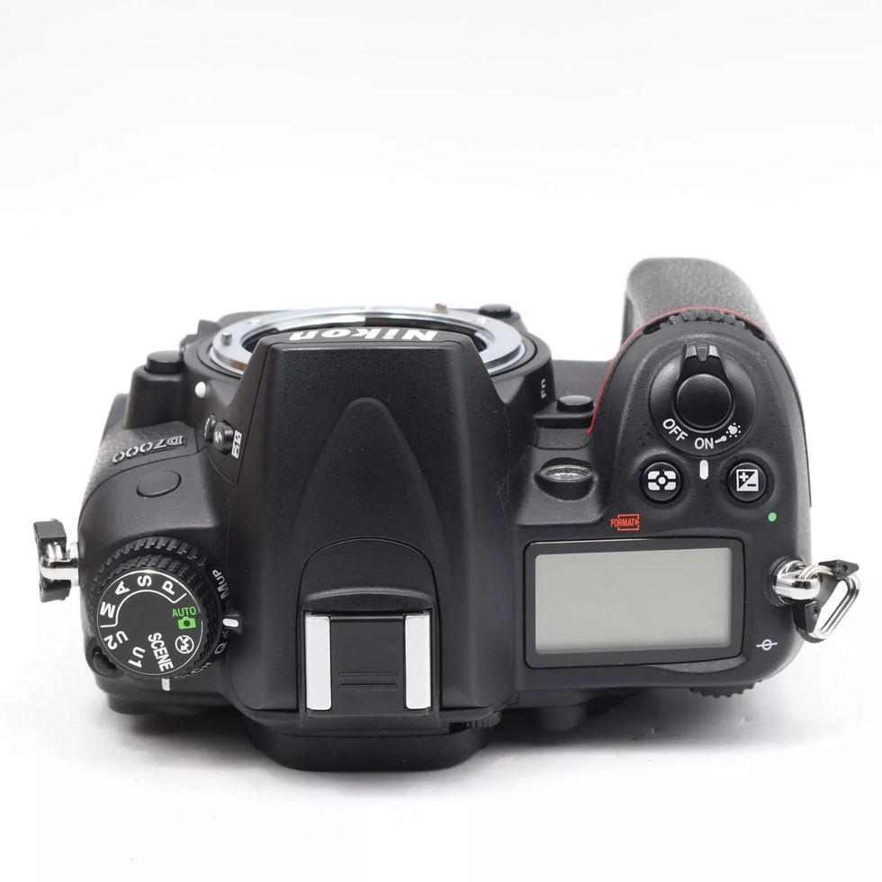 Black Nikon D70 DSLR camera top view on a white surface, ready to use.