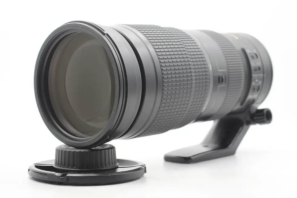 Close up of a long black camera lens; Vescar detail, white background.