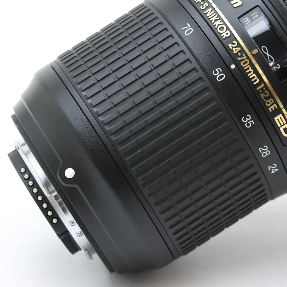 Close-up of a black camera lens with visible text and details.