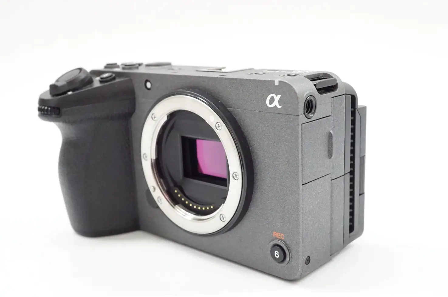 Gray Sony Alpha digital camera with lens mount, isolated on white background.