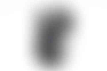 Black digital camera angled with screen facing viewer, on white background.