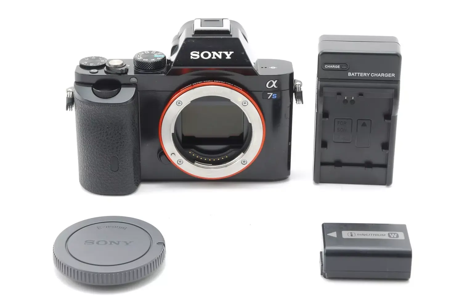 Black Sony Alpha camera, lens cap, and battery charger on white background.