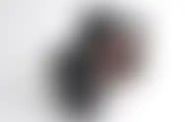 Black Sony a9 III camera with lens and other controls against white background