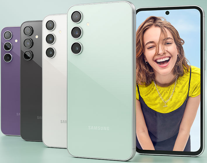 Three smartphones in different colors, a smiling person's face on display.