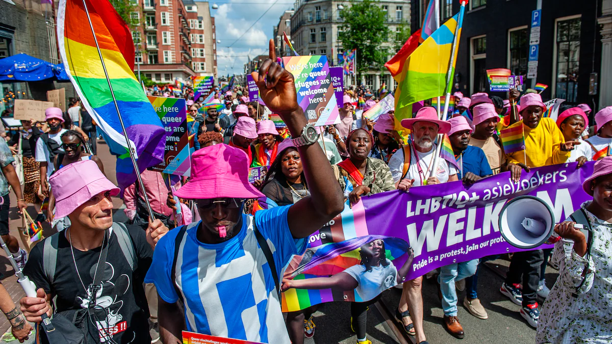 Queer protesters of color and allies marching during pride walk to say refugees are welcome in Amsterdam