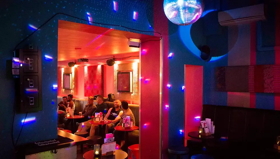 Amsterdam's gay bar Prik interior full of neon lights and cosy tables.