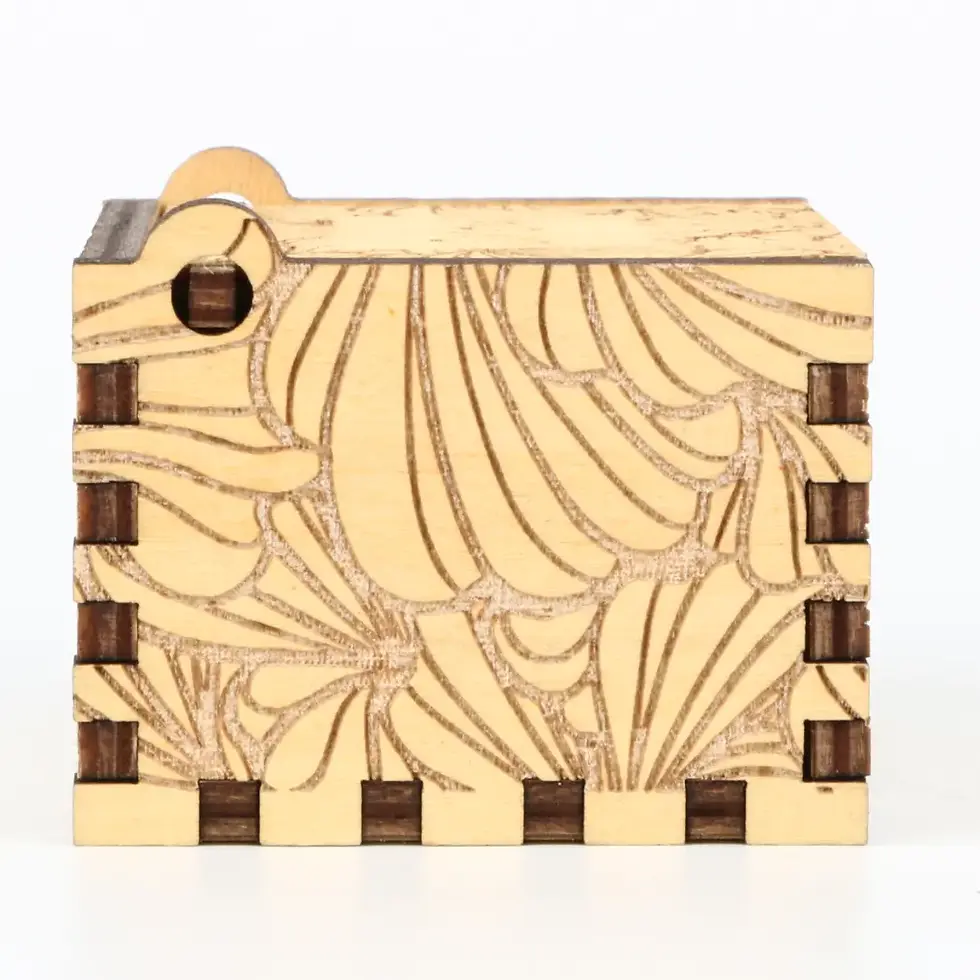 Miniatură: Detailed side view of a handcrafted wooden music box with unique swirling shell designs and interlocking wood joints.