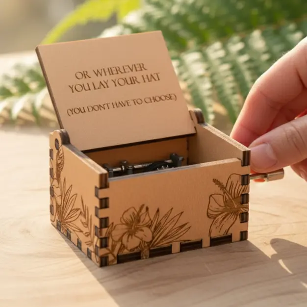 Tropical wooden music box with hand-crank. Engraved hibiscus & leaf design. Travel quote: "Wherever you lay your hat."