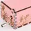 Thumbnail: Side view of a pink hand-crank wooden music box featuring intricate hibiscus floral engravings.