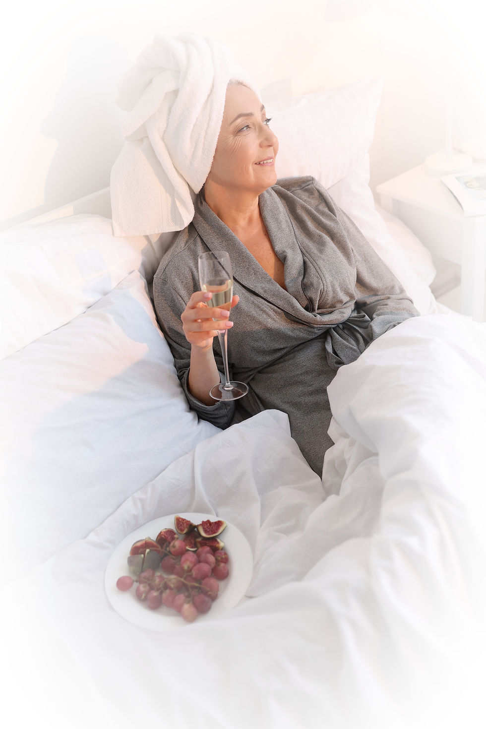 mature lady in bed with champagne