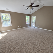 Bedroom with ceiling fan and windows overlooking the trees