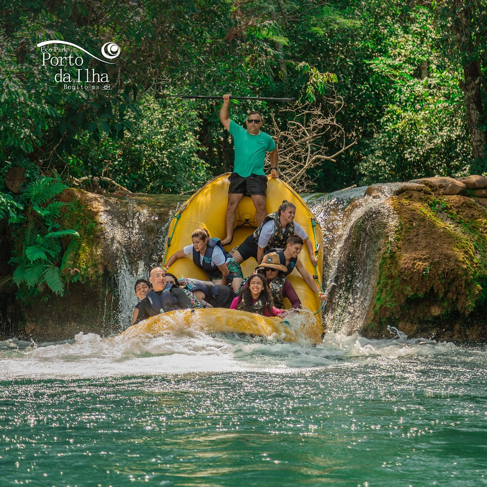 Grupo de pessoas descendo a cachoeira em bote inflável
