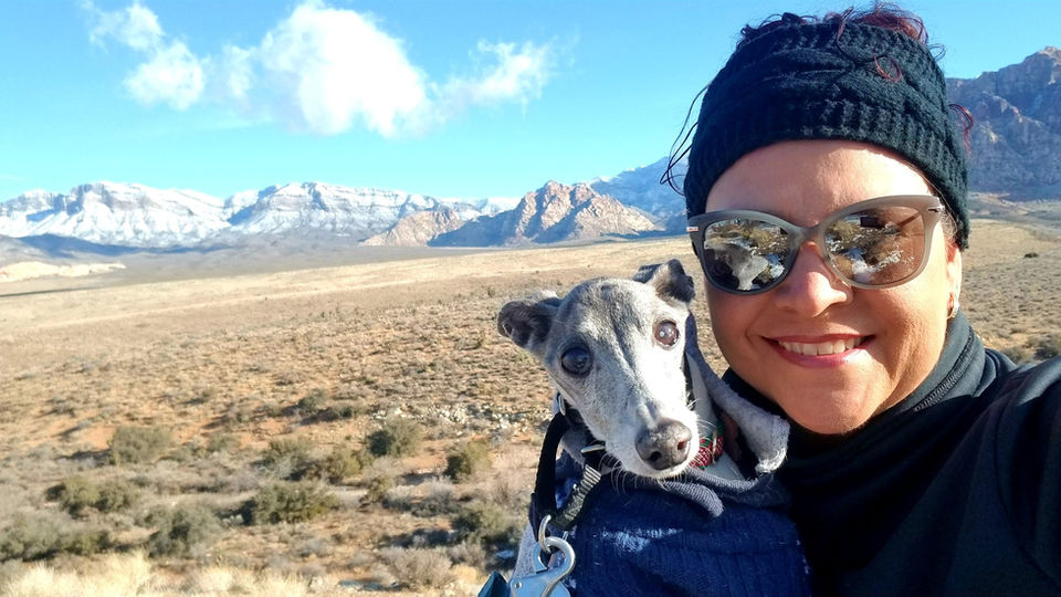 Denise with a dog on a hiking trail