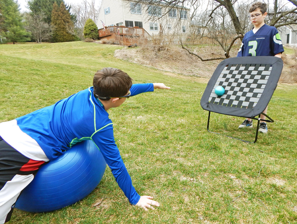 child on ball activity for core strength by kozie clothes
