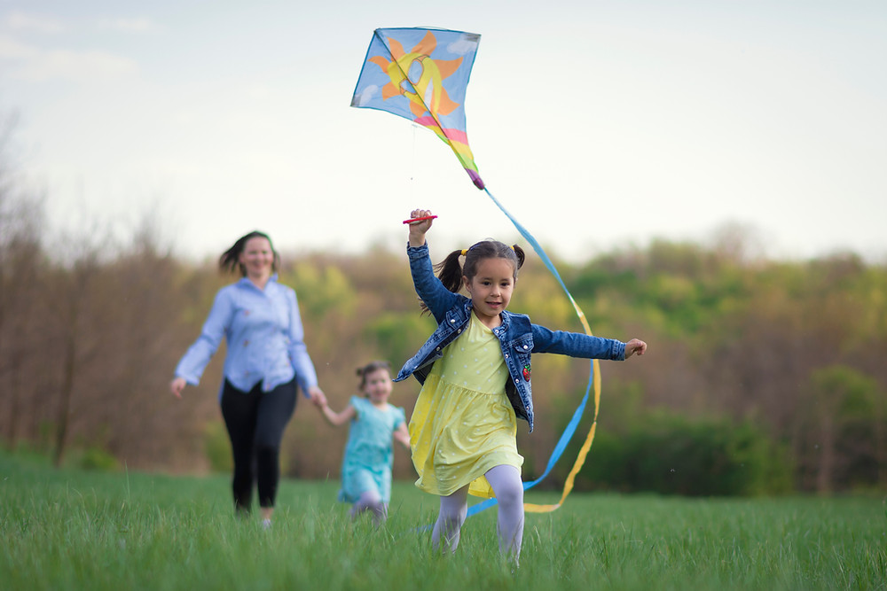 child flying kyte green spaces important for children by kozie clothes