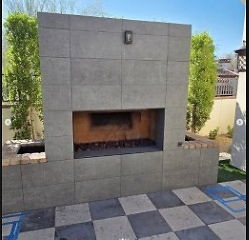 modern outdoor fireplace installation Phoenix AZ with large format tile