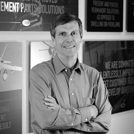Smiling man in blue shirt stands near