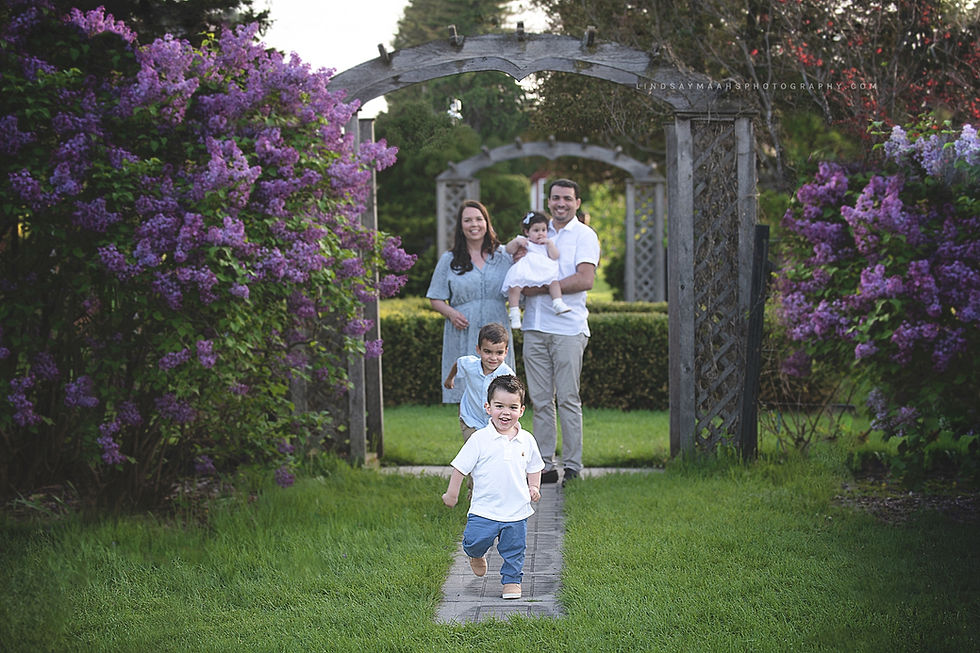 Family posing for a portrait and two boy siblings are running forwardhaving fun