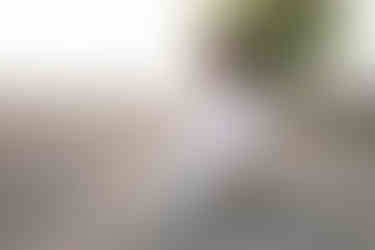 A boy in white playing in the sand on the beach