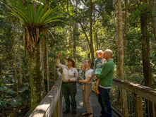 Ranger at Sea Acres Port Macquarie showing family a plant