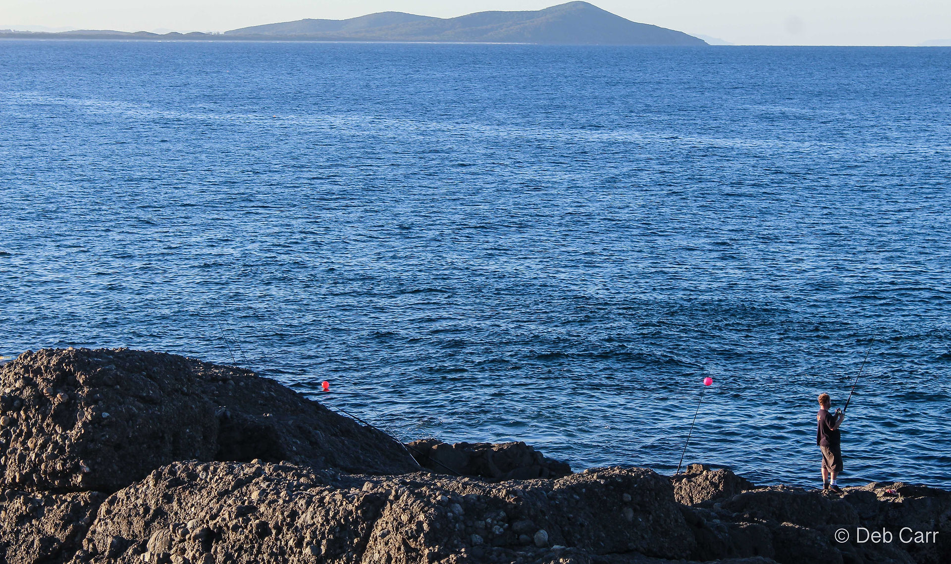 fisherman on rock in booti booti national park