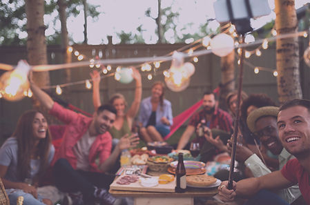 Outdoor party scene with people gathered around a table