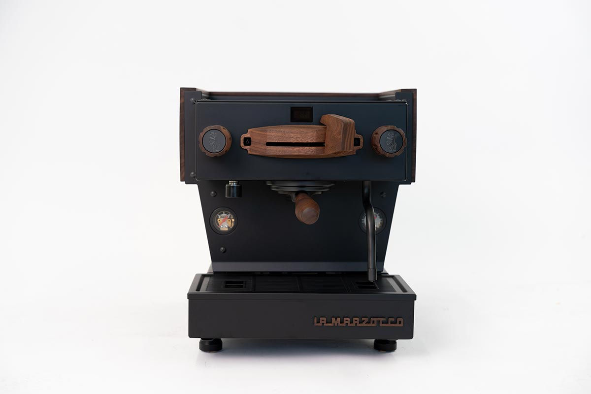 Frontal abgebildete, komplett schwarz beschichtete La Marzocco Linea Mini R, mit Walnussholz veredelt, plus Naked Manometer.