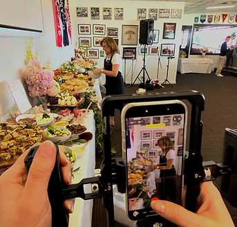 Behind-the-scenes smartphone filming of a catered event, capturing the food presentation and event atmosphere.