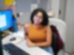 Smiling social worker sits at desk in office