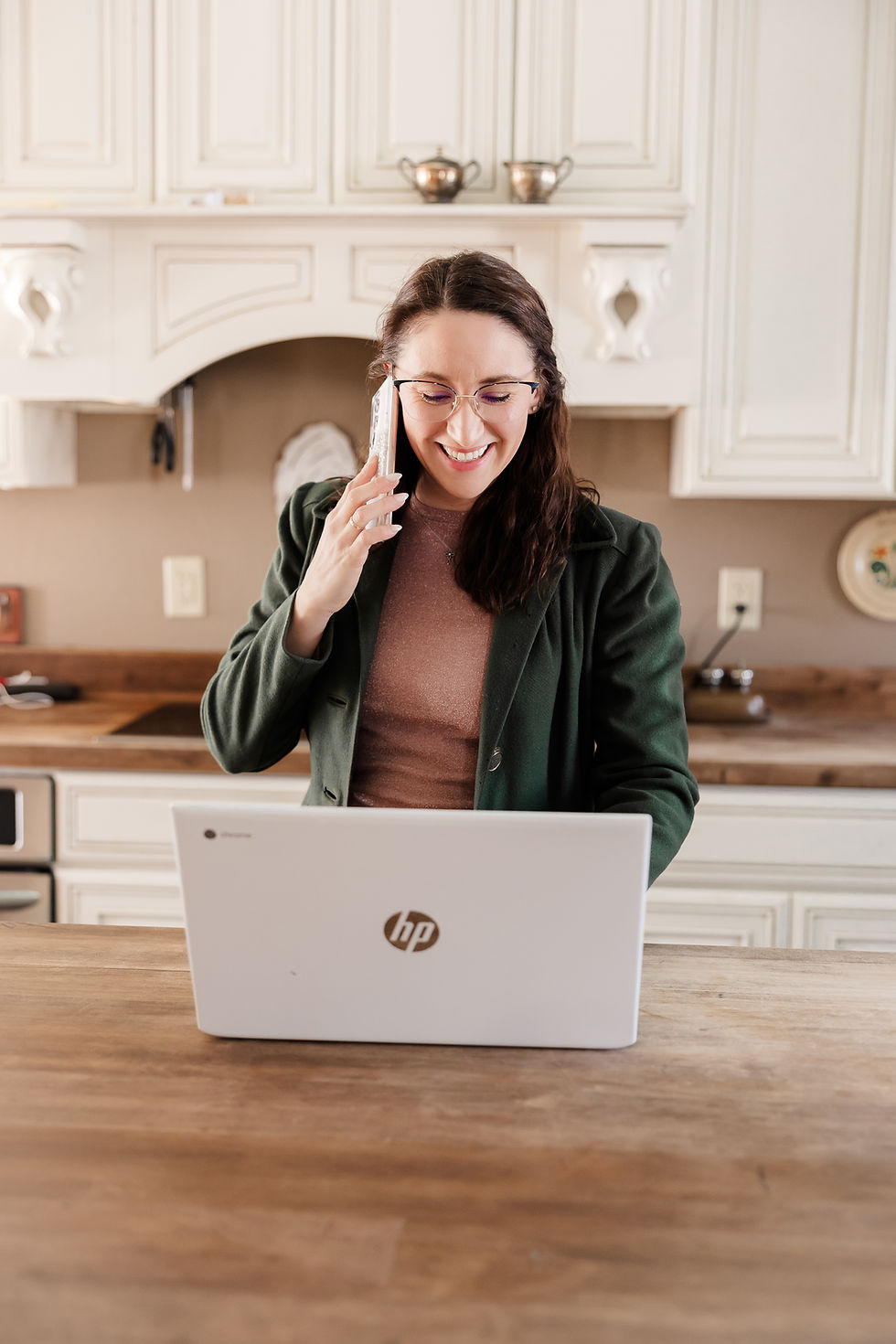 woman at a laptop, talking on the phone, Stone House Digital