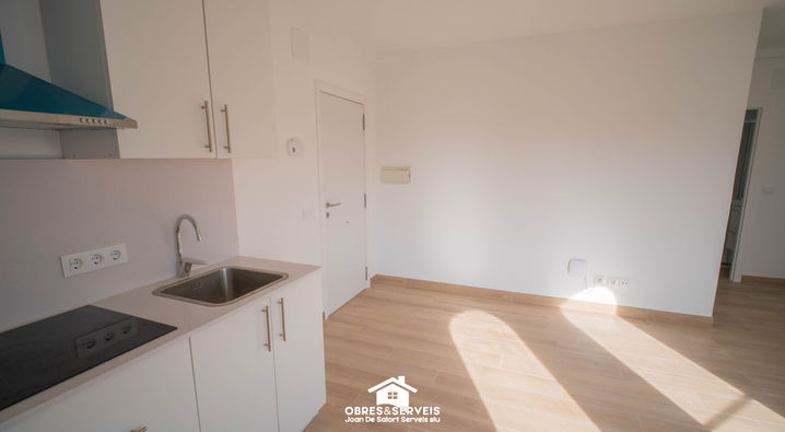 Puerta de entrada de apartamento reformado junto a cocina