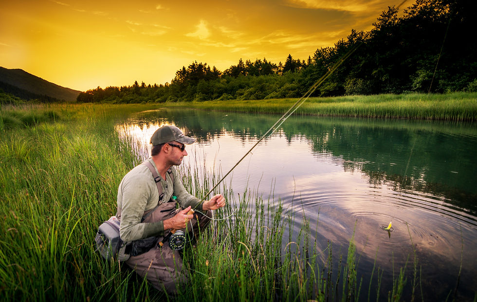 A fly fishermen waiting for a bite by a creek.