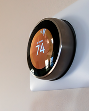 Wall-mounted smart thermostat inside dedicated home theater