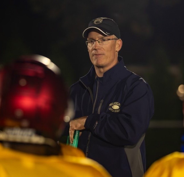 Football coach addressing his team at night
